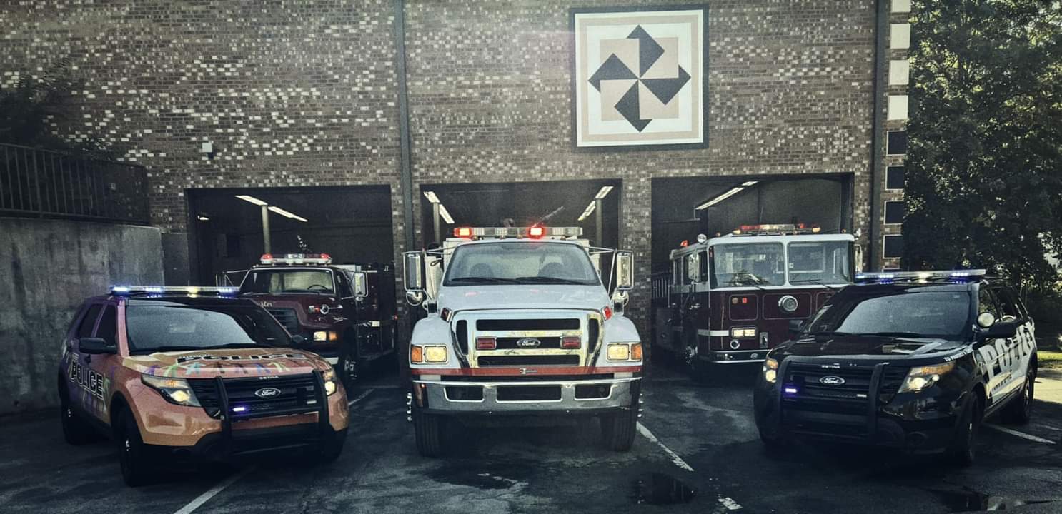 Police and fire vehicles lined up outside a station