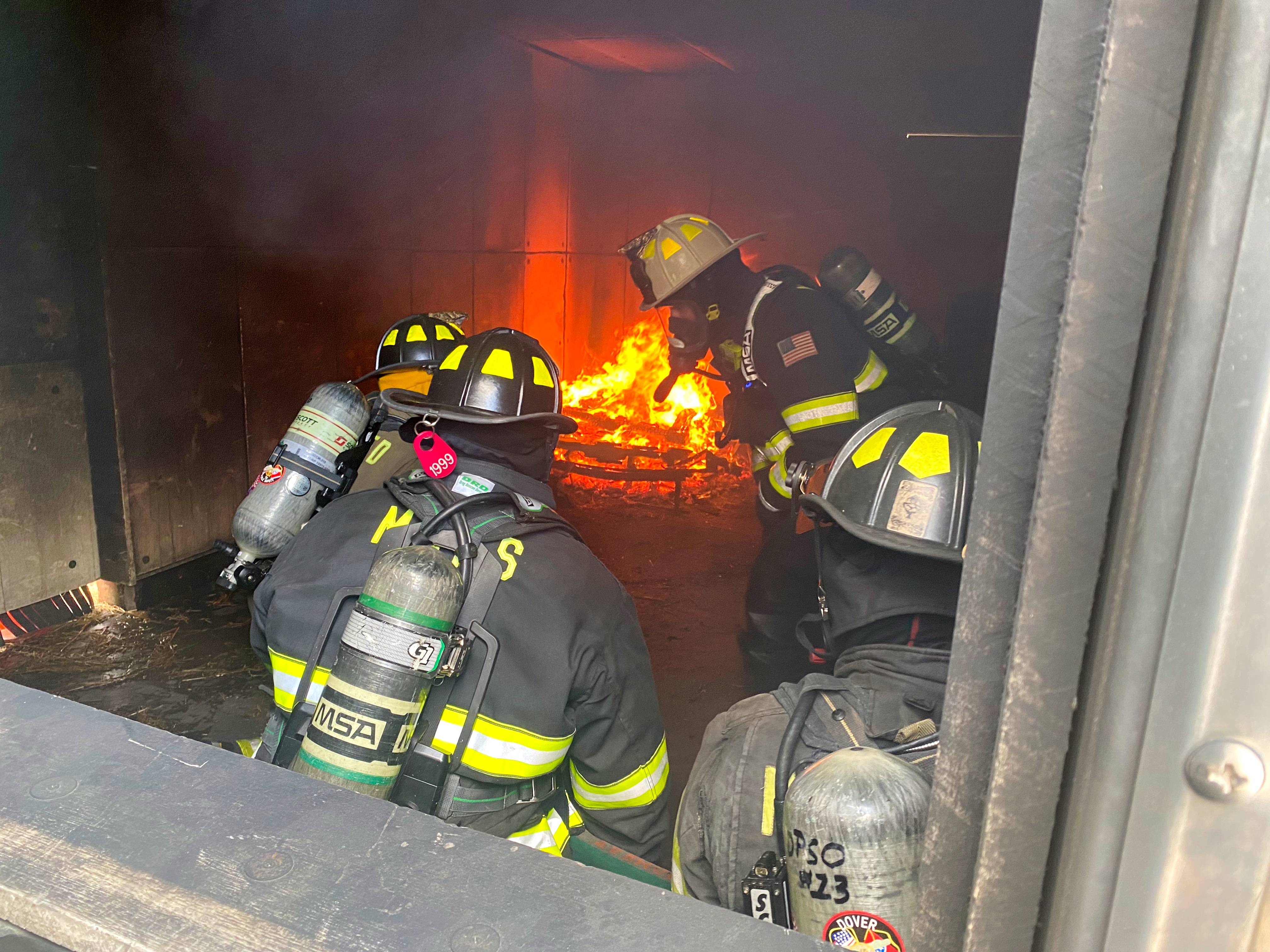 Firefighters operating inside a live-fire training environment